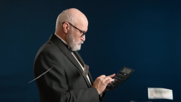 計算機を使用してスーツの成熟した男 青い背景に頭の上に浮かぶドル 財政的な成功を意味します 高品質の4K映像 — ストック動画