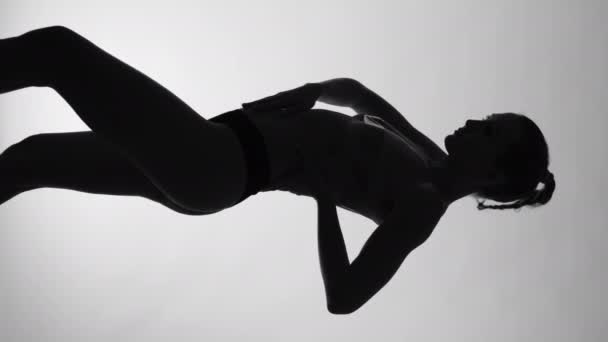 비디오는 형태에 매혹적인 연구를 보여주며 여성의 실루엣은 뚜렷하고 단색적인 환경에 — 비디오