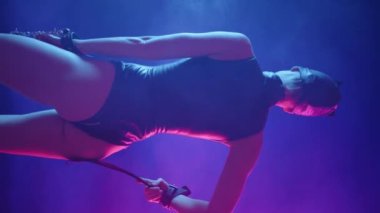 Dikey bir videoda, BDSM kedi kıyafeti giymiş şehvetli bir kadın sırtı kameraya dönük duruyor, baştan çıkarıcı bir şekilde vücudunda kırbacı nazikçe takip ediyor. Yüksek kalite 4k görüntü
