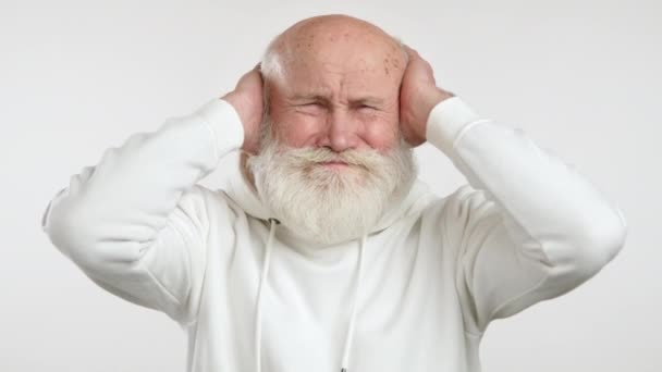 Этом Видео Пожилой Человек Белой Толстовке Гримасничает Закрывает Уши Руками — стоковое видео