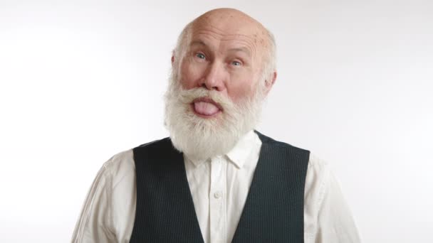 一个留着白胡子的成熟男人 穿着背心 在简单的白色背景下伸出舌头 表现出顽皮的一面 8K照相机 — 图库视频影像