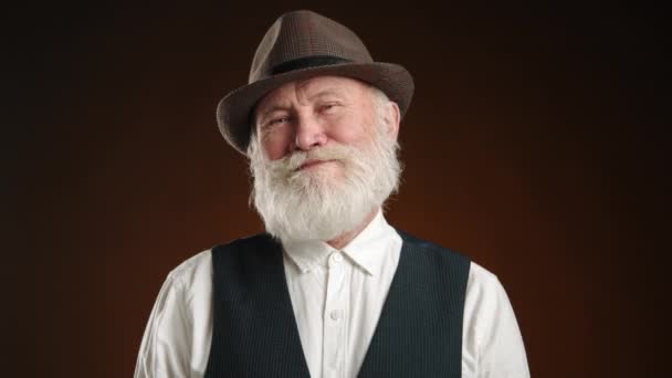 Ein Älterer Mann Mit Kariertem Hut Lächelt Und Nickt Zustimmend — Stockvideo