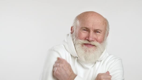 Ένας Γλυκός Ηλικιωμένος Άνδρας Ανοιχτόχρωμη Γενειάδα Λευκή Κουκούλα Δείχνει Κρυώνει — Αρχείο Βίντεο