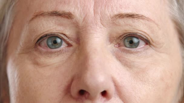高齢の女性の目と鼻の親密な接近 写真は 老化の詳細に鋭い焦点を当てて 経験と物語でいっぱいの深い視線をキャプチャします カメラ Raw — ストック動画