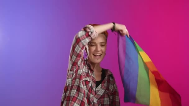 一位精力充沛的Lgbtq倡导者挥动彩虹旗 在鲜活的紫色背景下体现了骄傲和多样性的本质 8K照相机 — 图库视频影像