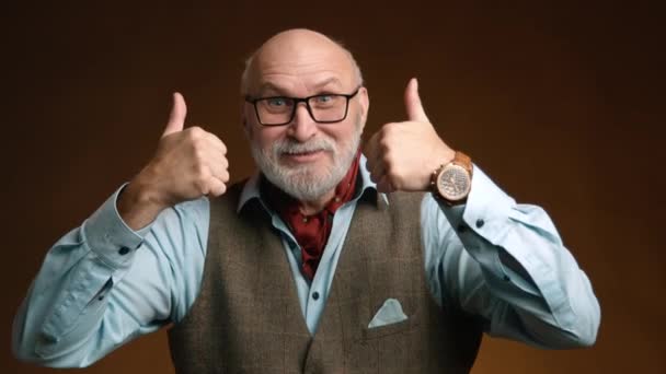 Sakallı Gözlüklü Mutlu Yaşlı Bir Adam Kahverengi Bir Stüdyo Arka — Stok video