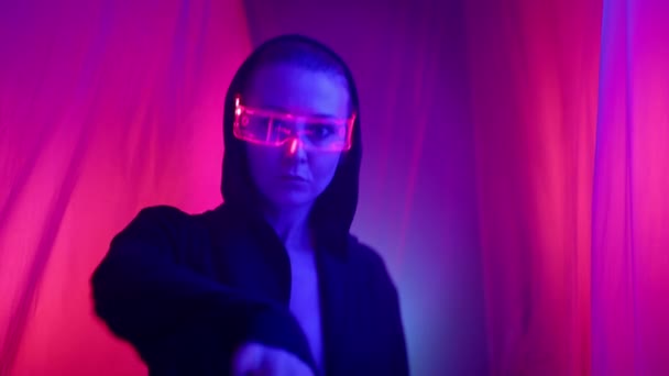 Cyberpunkowa Kobieta Czarnym Płaszczu Podświetlanych Okularach Porusza Się Elegancko Wśród — Wideo stockowe