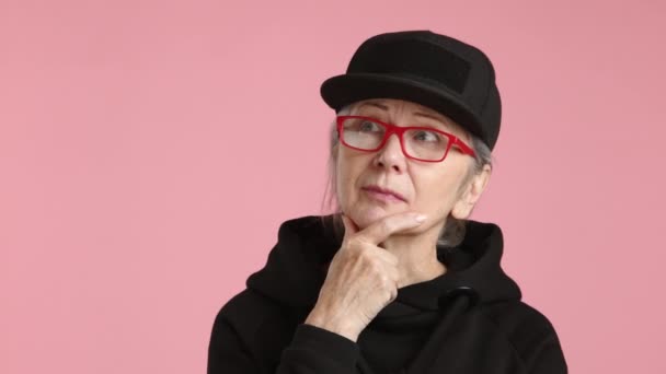 Eine Ältere Frau Mit Brille Und Schwarzem Hut Betrachtet Mit — Stockvideo