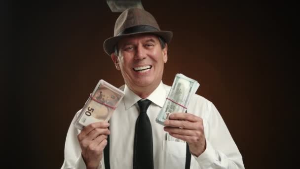 ヴィンテージの衣類の優れた男性は お金の請求書が彼の周りに散らばっているように笑い 暗い背景で富と成功を除外します 経済的な成功のイメージに最適です カメラ Raw — ストック動画