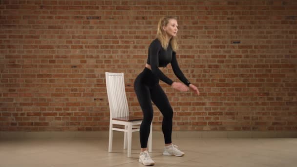 Fitness Profesionál Černém Oblečení Provádí Dřepy Židle Kombinující Sílu Rovnováhu — Stock video