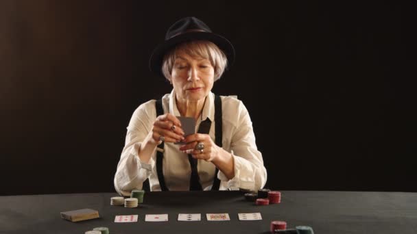キエフ ウクライナ 2023年1月14日 楽しい年配の女性は ゲームのスリルを反映して カジノテーブルでカードの勝利の手を保持し ポーカーのゲームを楽しんでいます カメラ Raw — ストック動画