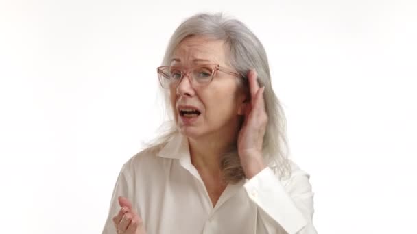 一位老妇人紧张地听着 她的手捂住耳朵 当她试图捕捉到遥远的声音或声音时 她的脸被白色的背景隔开了 8K照相机 — 图库视频影像