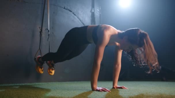 一位执着的健身爱好者通过具有挑战性的Trx暂停练习完善了她的腹部运动 展示了她在城市体育馆气氛中的集中精神和力量 8K照相机 — 图库视频影像