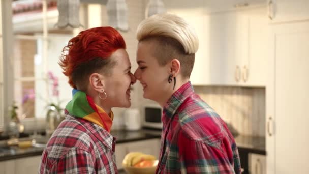 彼らのキッチンでは レズビアンカップルは密接な抱擁を共有し 彼らの顔は 愛と彼らのつながりの暖かさに包まれ 明るい笑顔と国内の幸せの柔らかい輝きを共有しています — ストック動画
