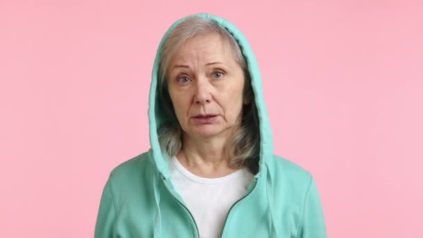 Een Serieus Uitziende Senior Dame Een Groene Hoodie Met Een — Stockvideo