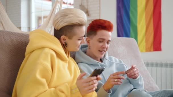 リラックスしたホームセッティングのレズビアンカップルは オンラインショッピングに従事し スマートフォンにクレジットカードの詳細を入力し 信頼と共有財政の兆候 高品質の4K映像 — ストック動画