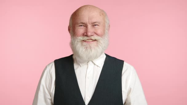 Приятный Пожилой Мужчина Мягкой Улыбкой Белая Борода Контрастирует Розовым Фоном — стоковое видео