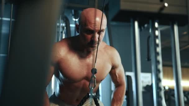 Ein Glatzköpfiger Muskulöser Mann Trainiert Intensiv Einem Fitnessstudio Und Zieht — Stockvideo