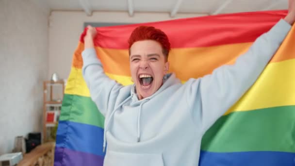 在一个充满自豪和自由的情感展示中 一个红头发的充满活力的女同性恋者高兴地升起了五彩缤纷的彩虹旗 象征着爱情和Lgbtq的身份 高质量的4K镜头 — 图库视频影像