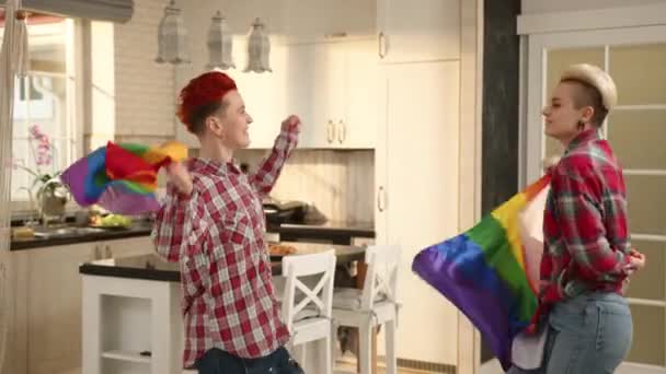 Lesbian Couple Dances Joyfully Kitchen Waving Rainbow Flag Moving Sync — Stock Video