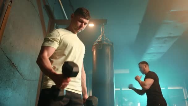 Skoncentrowany Mężczyzna Zwykłej Koszulce Robi Loki Bicepsowe Ciężkimi Hantlami Nowoczesnej — Wideo stockowe