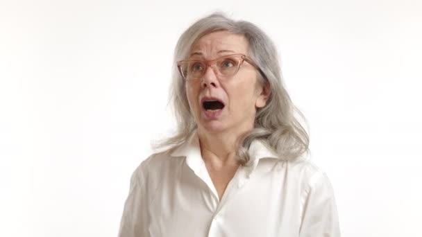祖母突然打了个喷嚏 当她捂住嘴时 她的头发乱飞 这是在白色背景下一个滑稽而自然的人类时刻 — 图库视频影像