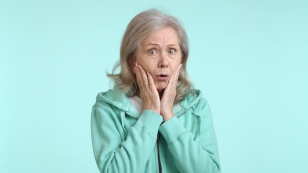 Eine Aufgeschreckte Ältere Frau Einem Grünen Kapuzenpullover Bedeckt Ihren Mund — Stockvideo