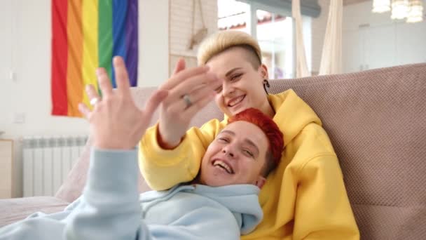 Радісна Лесбійська Пара Відзначає Заручини Зручному Дивані Грайливо Показуючи Свої — стокове відео