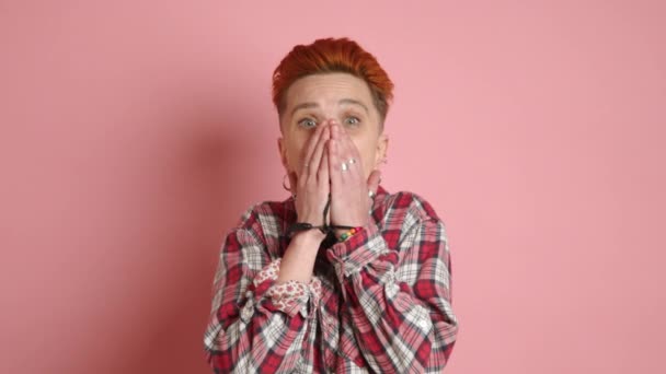 一个受惊的女同性恋者震惊地反应 用手捂住嘴 在柔和的粉色背景上真实地表现出惊讶和惊讶的表情 8K照相机 — 图库视频影像