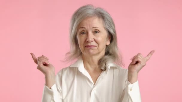Yaşlı Bir Kadın Kulaklarını Tıkayarak Parlak Pembe Bir Arka Plana — Stok video