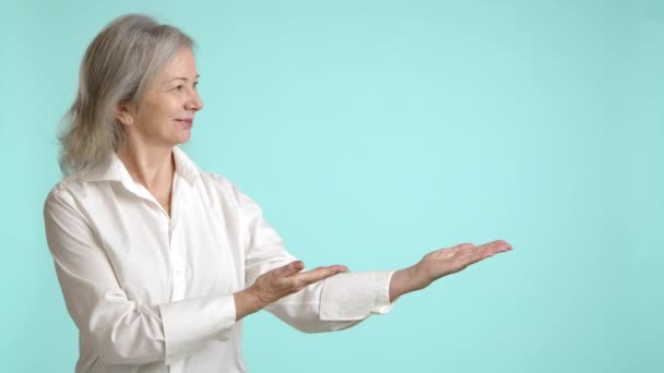Elegante Senior Vrouw Een Witte Blouse Gebaren Uitnodigend Naar Lege — Stockvideo