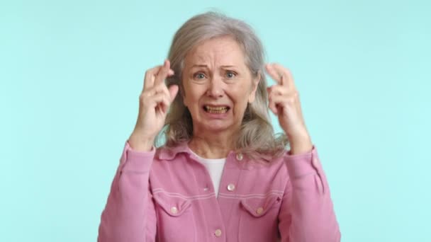 Оптимистичная Пожилая Женщина Скрещенными Пальцами Жесте Надежды Ожидания Розовой Рубашке — стоковое видео
