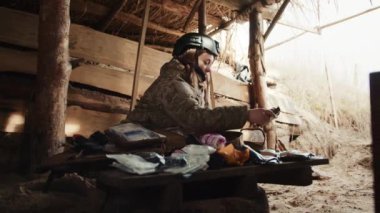 Bir kadın askeri doktor sığınakta oturuyor, tıbbi malzemelerini titizlikle düzenliyor, yaralı askerlere gerekli tıbbi hizmetleri sunmaya hazırlanıyor. Kamera 8K HAM. 