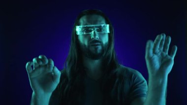 Arttırılmış gerçeklik gözlüğü takan, elleri görünmez bir klavyeye yazılmış, gelecek nesil kullanıcı arayüzlerinin potansiyelini temsil eden bir adamın geleceksel görüşü. Kamera 8K HAM. 