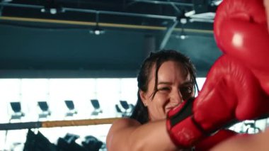 Kararlı bir bayan sporcu, tekniğinin hassaslığını ve becerisini vurgulamak için saniyede 120 kare ile yavaş çekimde yakalanan profesyonel bir ringde boks yapıyor. Kamera 8K HAM. 