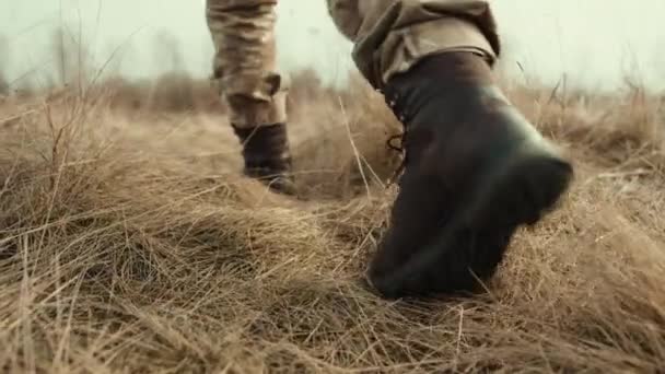 Military Woman Moves Solo Desolate Field Dry Yellow Grass Crunching — Stock Video