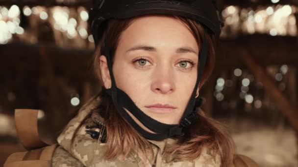 クローズアップビューは 彼女のヘルメットに囲まれた女性兵士の顔を捉え 彼女の目は彼女の役割の重力と戦争の劇場で必要とされる断固とした精神を反映しています カメラ Raw — ストック動画