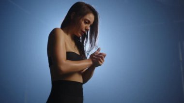 Yoğun bakışları olan genç bir bayan sporcunun el çırpması ve dingin mavi bir spor salonunda dönen güzel tebeşir tozu bulutları göndermesi, eğitim öncesi odak noktasını belirginleştiriyor. Kamera 8K HAM.