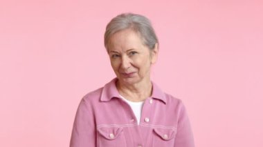 Pembe ceketli mutlu bir son sınıf öğrencisi sıcak bir şekilde gülümsüyor, gözleri sevinçle parıldıyor ve mutlulukla dolu bir kalbi yansıtıyor.. 