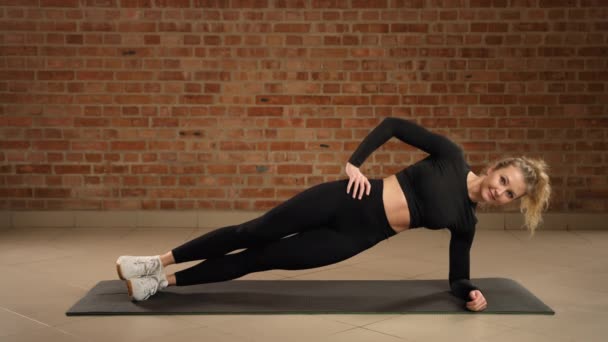 Een Moderne Fitnessruimte Een Trainer Voert Een Side Plank Pose — Stockvideo
