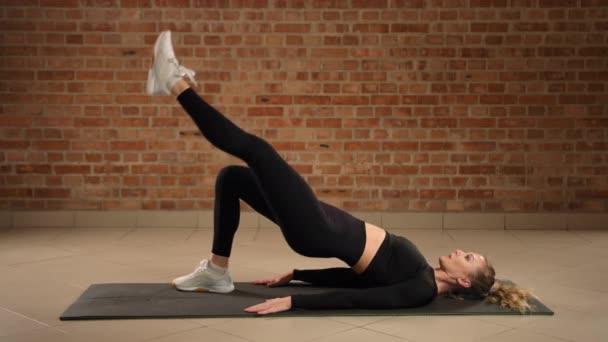 Professional Fitness Instructor Demonstrates Single Leg Hip Bridge Left Leg — Stock Video