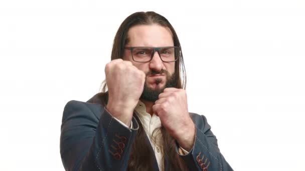 長い髪とひげで決められたビジネスマンは攻撃的なジェスチャーを作り 白い背景で強さや葛藤のショーで拳をクレンジングします カメラ Raw — ストック動画