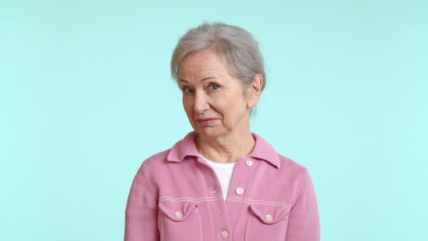 Starší Žena Vřelým Úsměvem Růžové Košili Vyzařuje Konejšivém Světle Modrém — Stock video