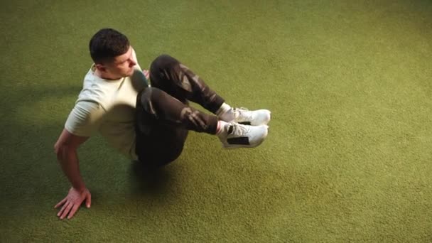 Ein Mann Lässigen Sportoutfit Führt Auf Einem Künstlichen Grünen Boden — Stockvideo
