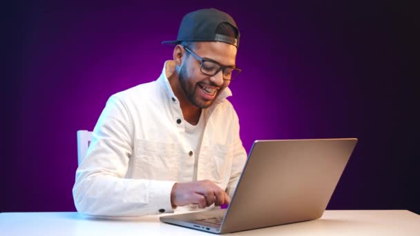 치과용 보조기를 착용한 아프리카계 미국인 남성은 캐주얼한 재킷과 세련된 노트북에서 — 비디오