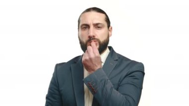 Akıllı giyimli bir işadamı ağzına kilit hareketi yaparak, iş uygulamalarında gizlilik ve sağduyunun önemini işaret eder. Kamera 8K HAM. 