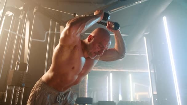 裸の胴体を持つ筋肉男性は 現代のジムの設定で彼の上半身の筋肉をターゲットに 激しいケーブルクロスオーバーワークアウトに従事しています カメラ Raw — ストック動画