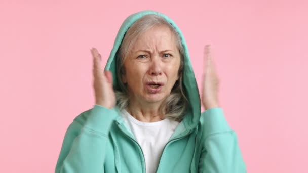 Расстроенная Пожилая Женщина Закрывает Уши Руками Показывая Тревожную Реакцию Громкий — стоковое видео