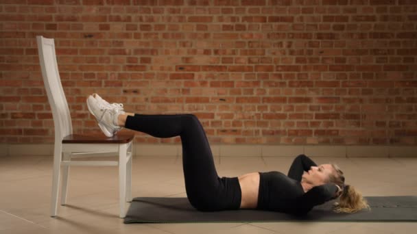 Fitness Expert Instructs Elevated Feet Crunches Using Chair Intensifying Core — Stock Video
