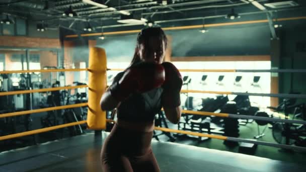 一个女拳击手的轮廓被拍摄到向摄像机投出精确的直拳 她的形象因体操馆戏剧性的背光而更加突出 8K照相机 — 图库视频影像